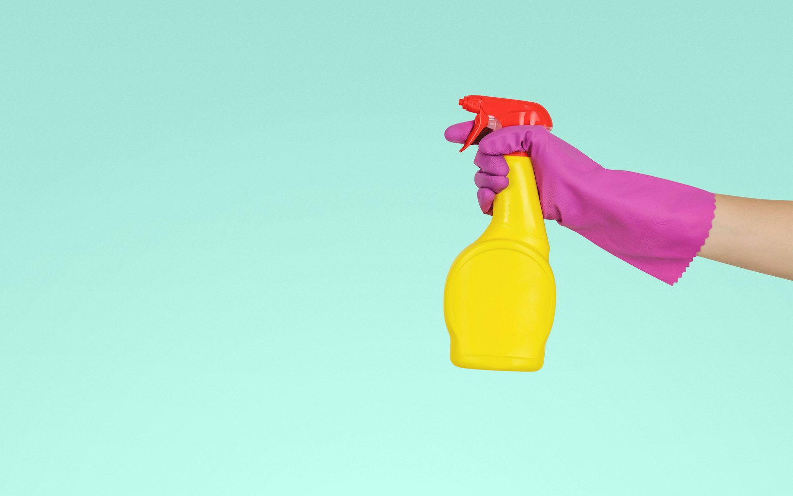 person holding yellow plastic spray bottle
